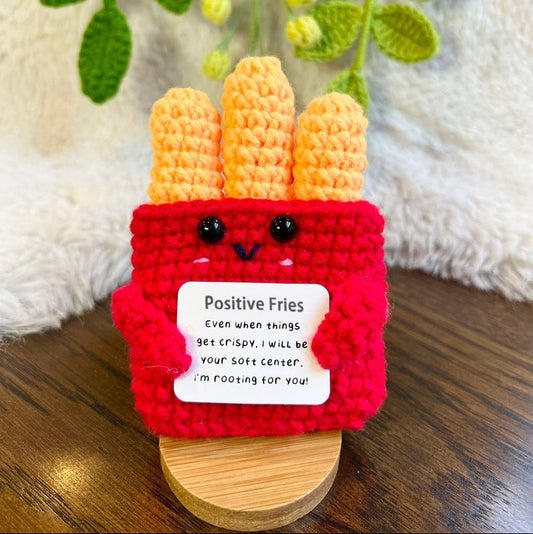 handmade knitted packet of french fries on a stand with a positive message on a sign
